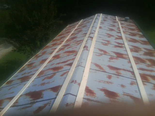 Rusted metal roof panels with new wood purlins before replacement — Storm Damage Roof Repair in Topping by Roofing Brothers