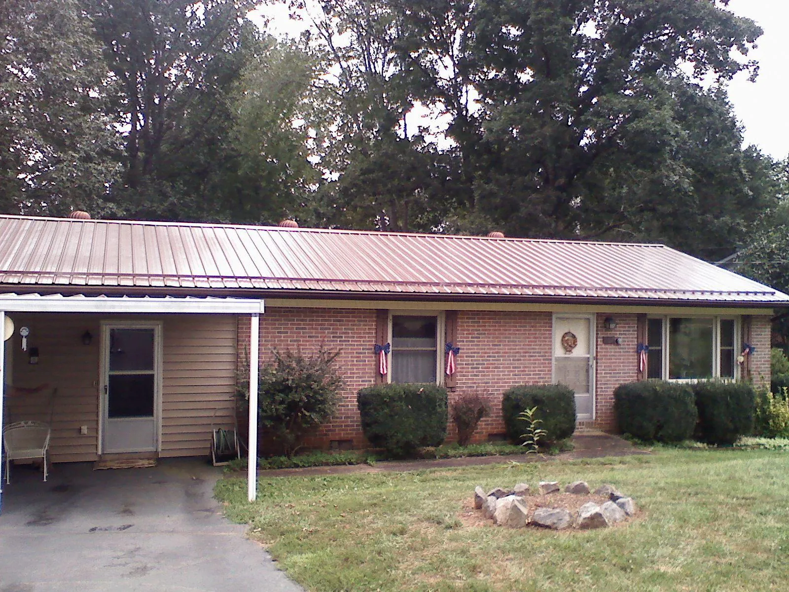 Bronze metal roof and carport on a brick ranch home — Roof Repair work by our crew in Topping