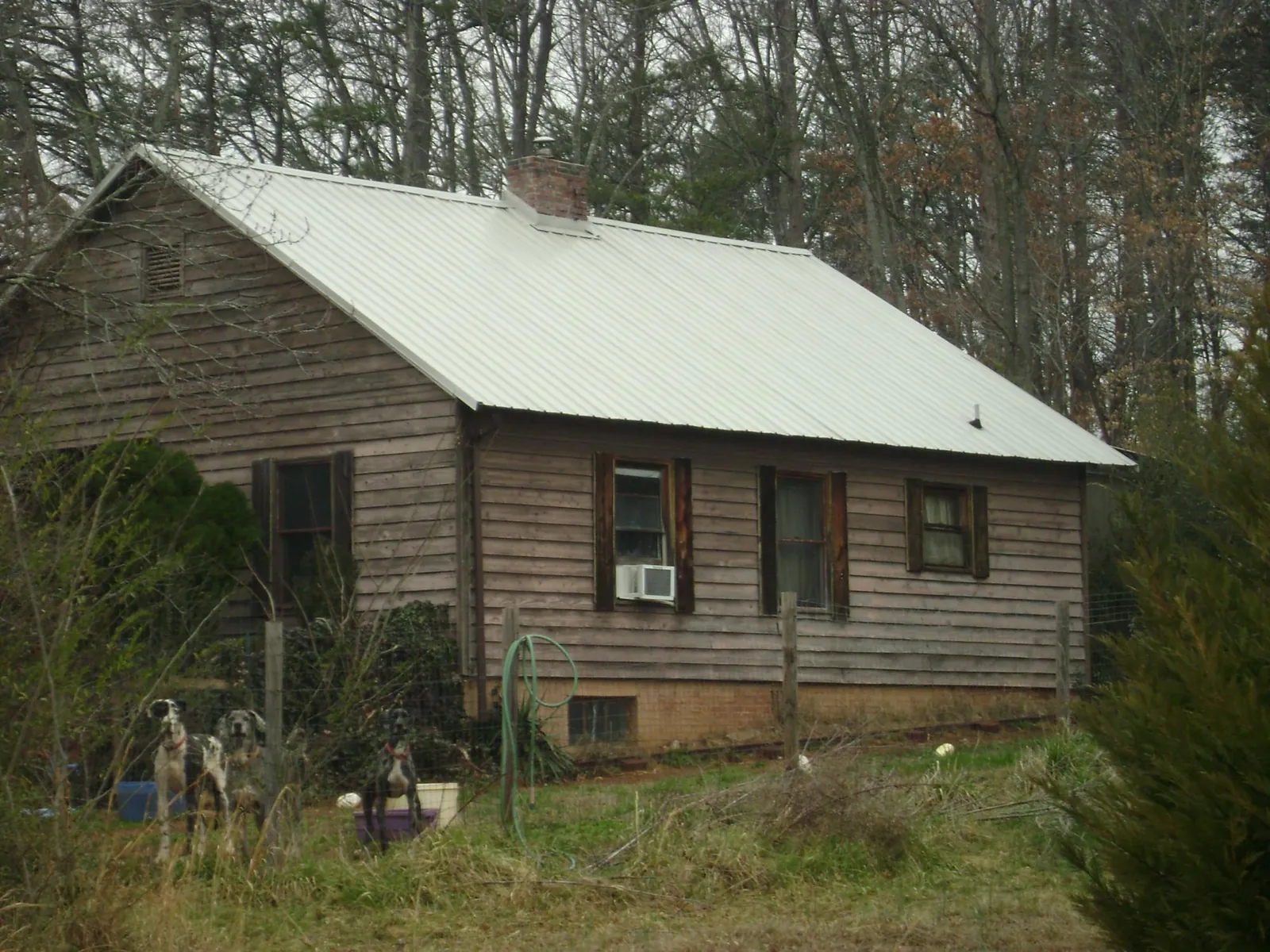 White metal roof on an old wood sided farmhouse, from a Metal Roof Installation job in Topping